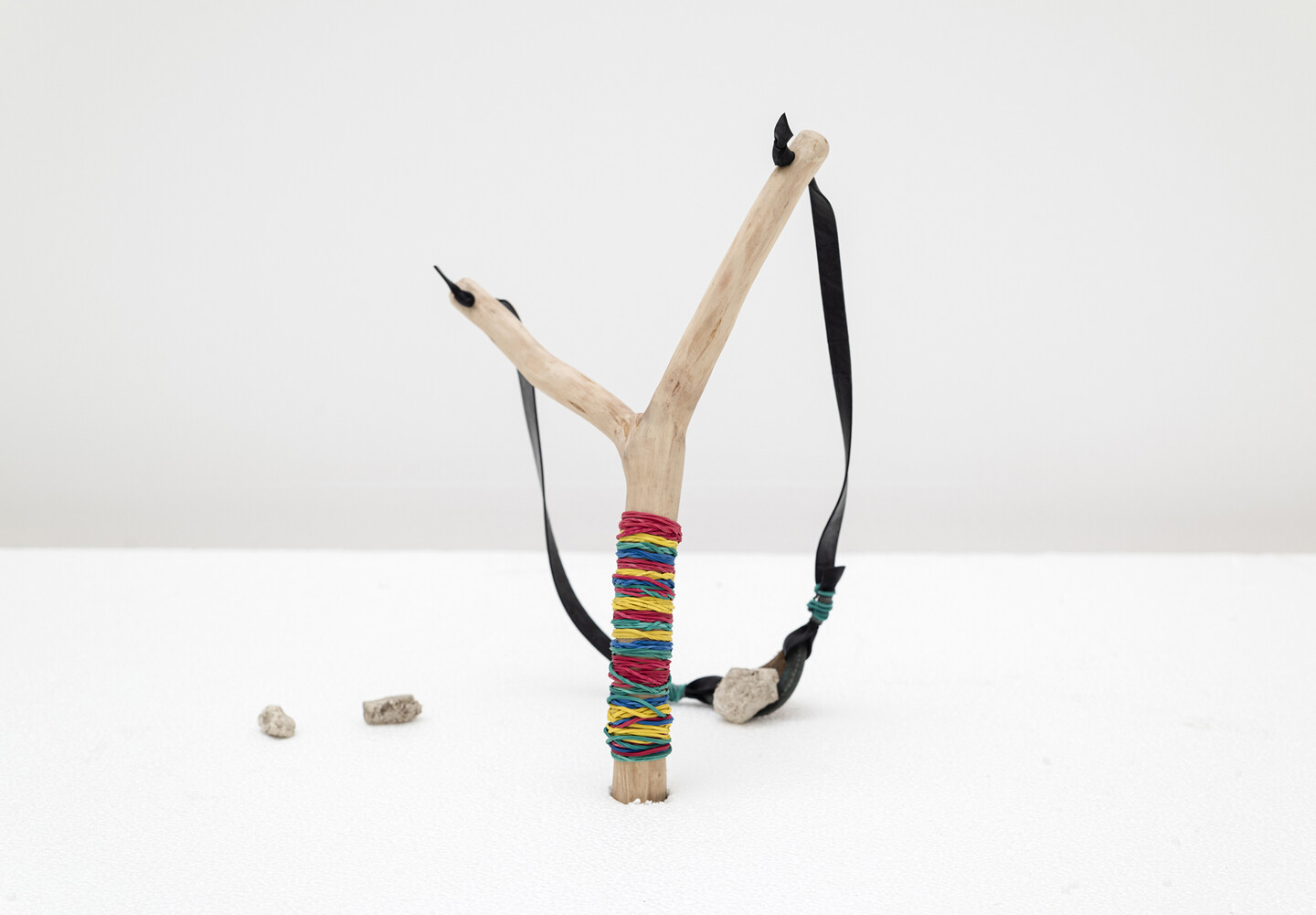 Slingshot, 2024, Wood, rubber, stones, leather, 35 × 65 cm