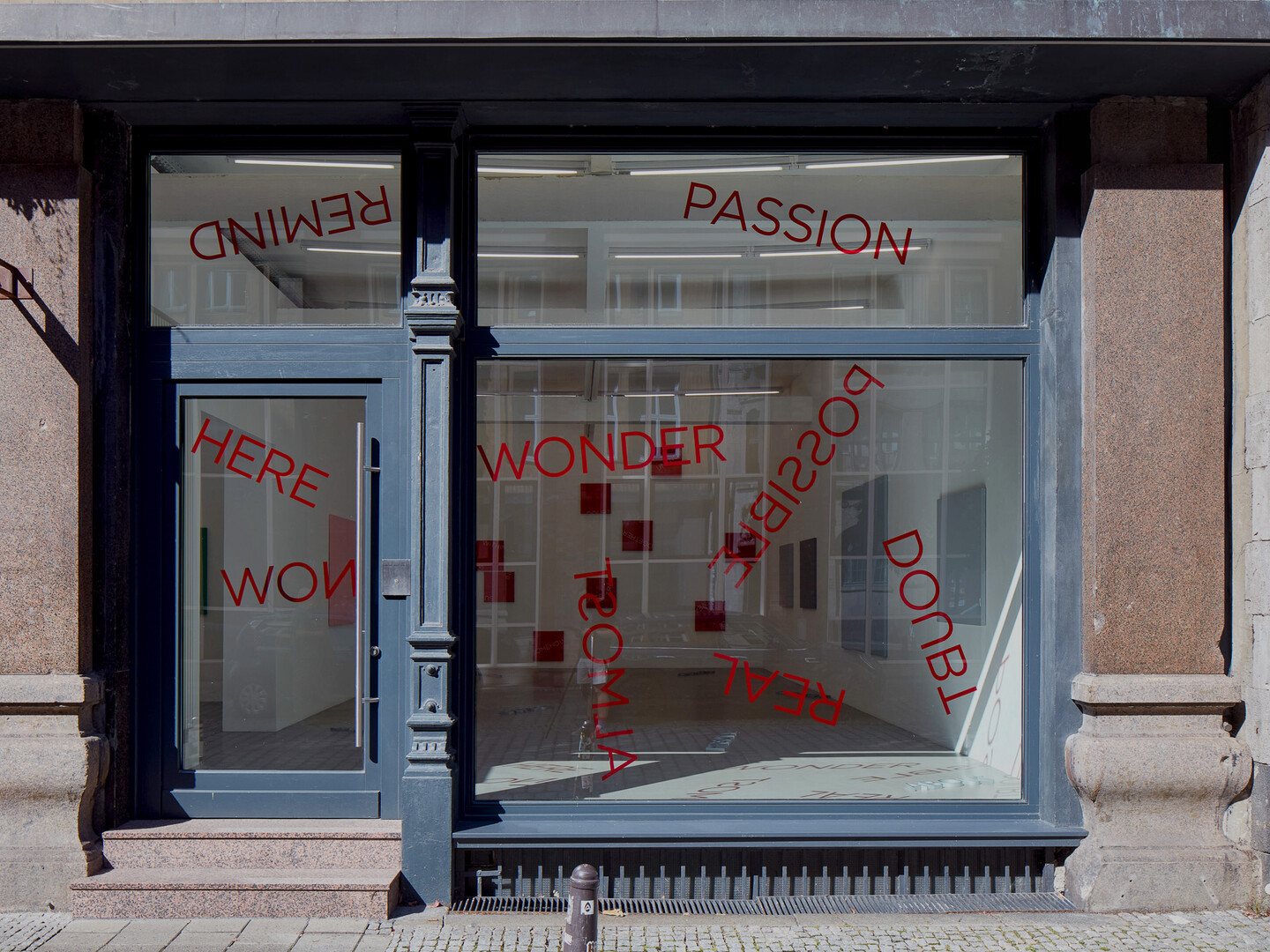Untitled, 2024, 19 red foil words on window, Dimensions variable